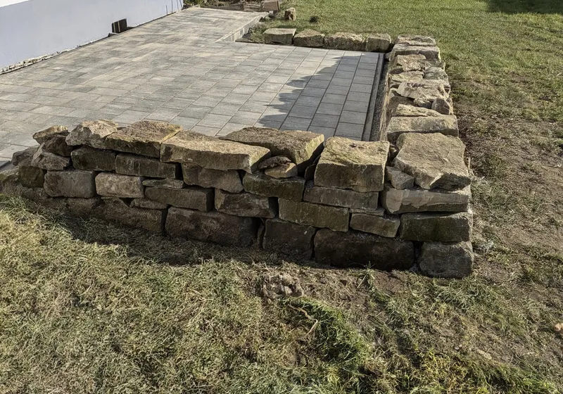 Neue Terrasse mit Naturstein-Stützmauer